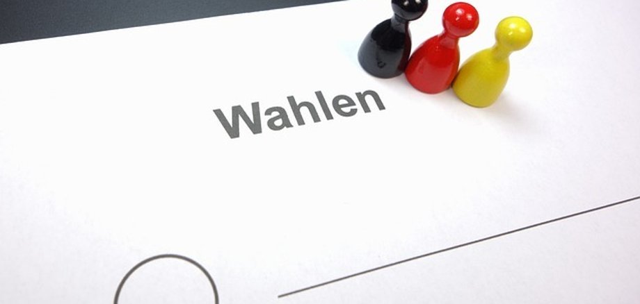 Spielfiguren (schwarz-rot-gold) auf einem Wahlzettel
