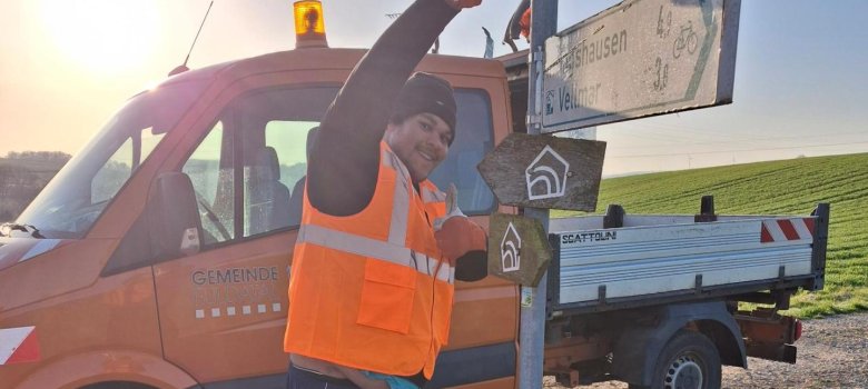 Herr Benjamin Yaya vom Baubetriebshof der Gemeinde Fuldatal bringt eines der neuen Schilder im Bereich Weidberg im Ortsteil Simmershausen an. Herr Benjamin Yaya vom Baubetriebshof der Gemeinde Fuldatal bringt eines der neuen Schilder im Bereich Weidberg im Ortsteil Simmershausen an.