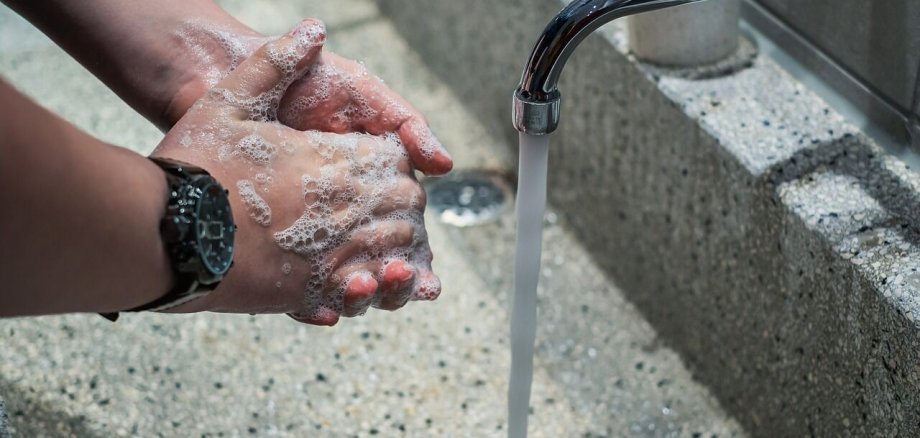 Bild von Händewaschen in einem Waschbecken unter fließendem Wasser