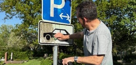 Bürgermeister Florin reinigt ein Verkehrsschild