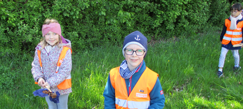 Kinder bei der Sammelaktion Das Bild zeigt drei Kinder bei der Müllsammelaktion.