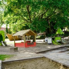 Bild des Außengeländes der Kita Simmershausen mit Sandkästen, Rutschen und Klettermöglichkeiten