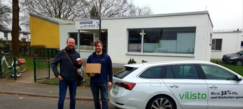 Klimaschutzmanager und Installateur vor der Kita Weddel