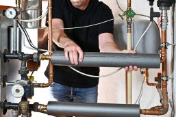 Heizung erneuern Mann arbeitet an Heizung